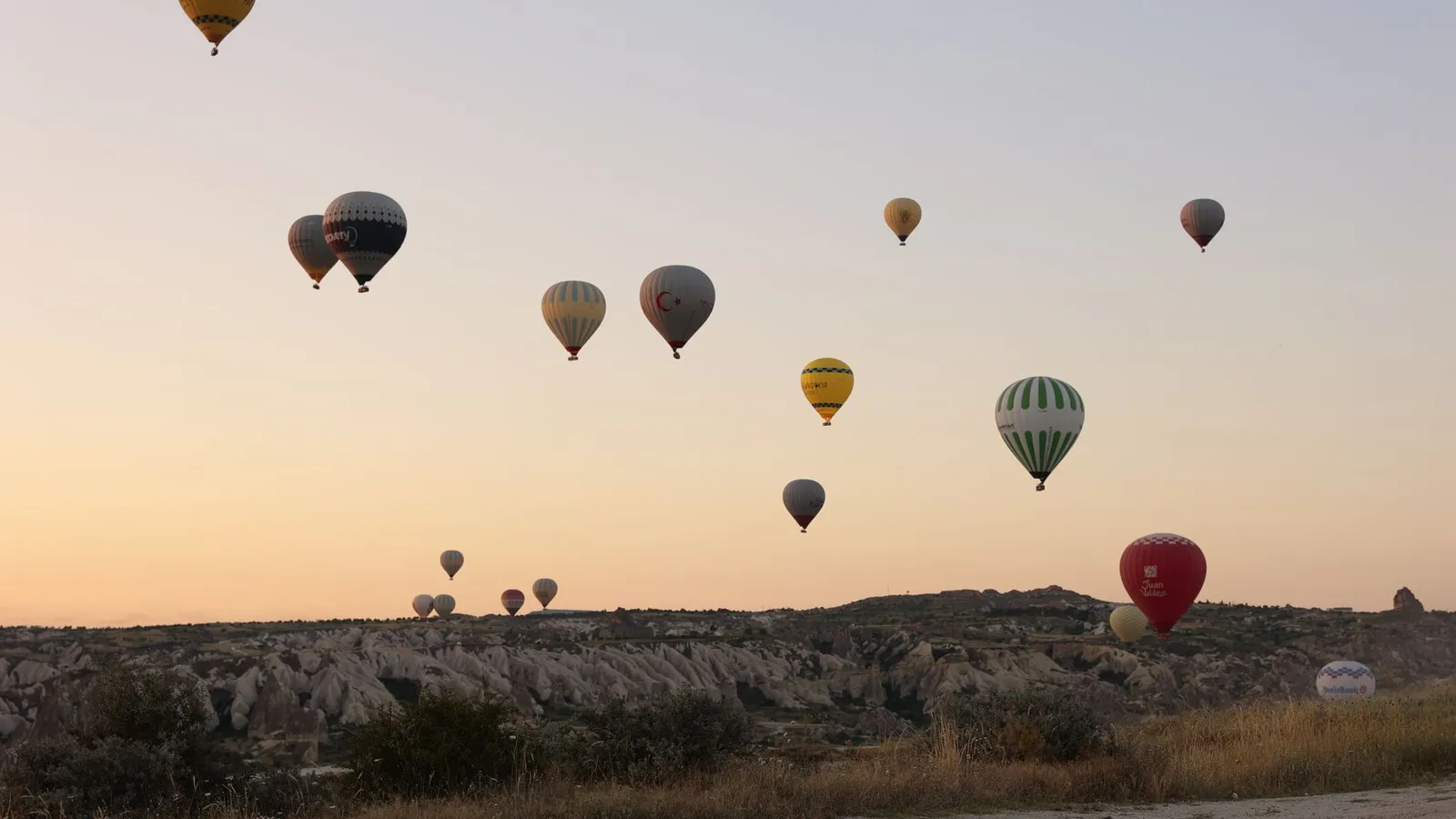 Hot air balloons drifting over Goreme at sunrise, Cappadocia