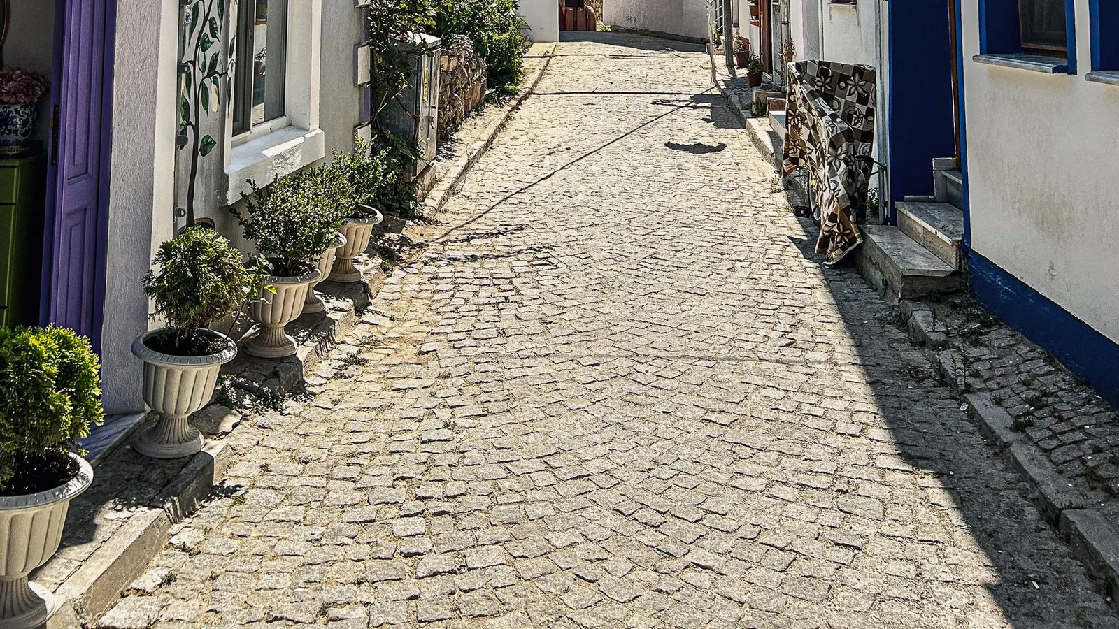 Cobblestone street with old stone houses in Alacati, Cesme